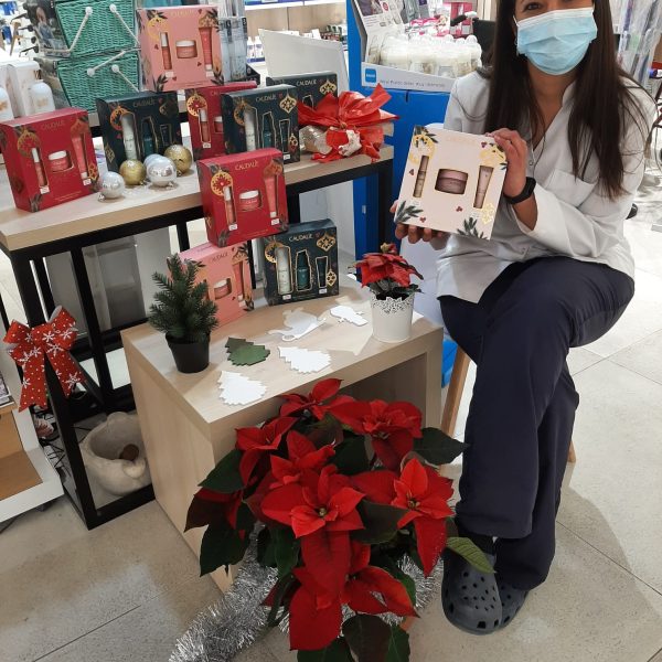Trabajadora de Farmacia Puig con flores y productos de cuidado facial